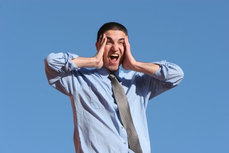 Surprised businessman on blue sky background